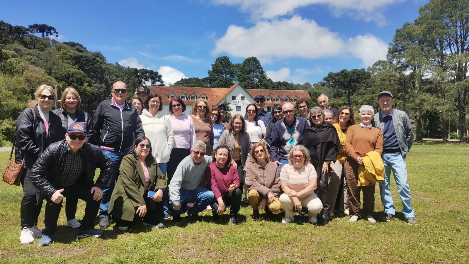 Grupo de passageiros da Almeida Viagens reunido no gramado em frente ao hotel
